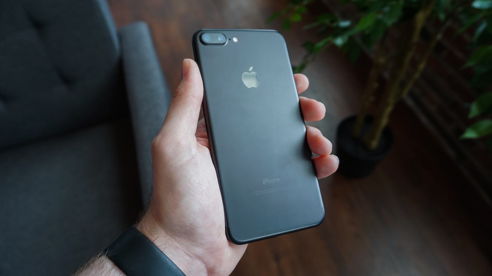 A hand holding a black smartphone